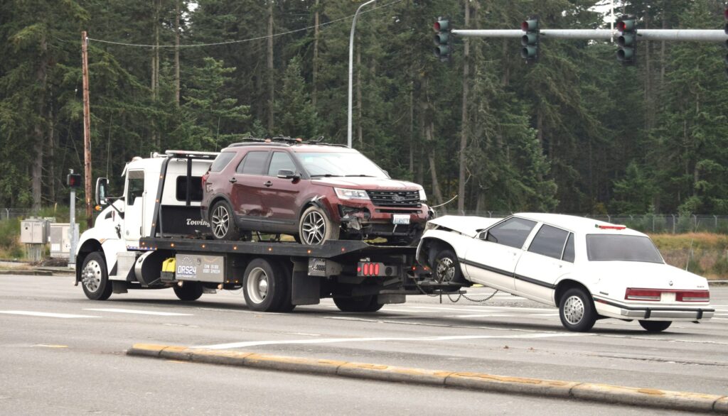 Damaged cars being towed after a collision; a scenario where uninsured motorist coverage may be necessary.